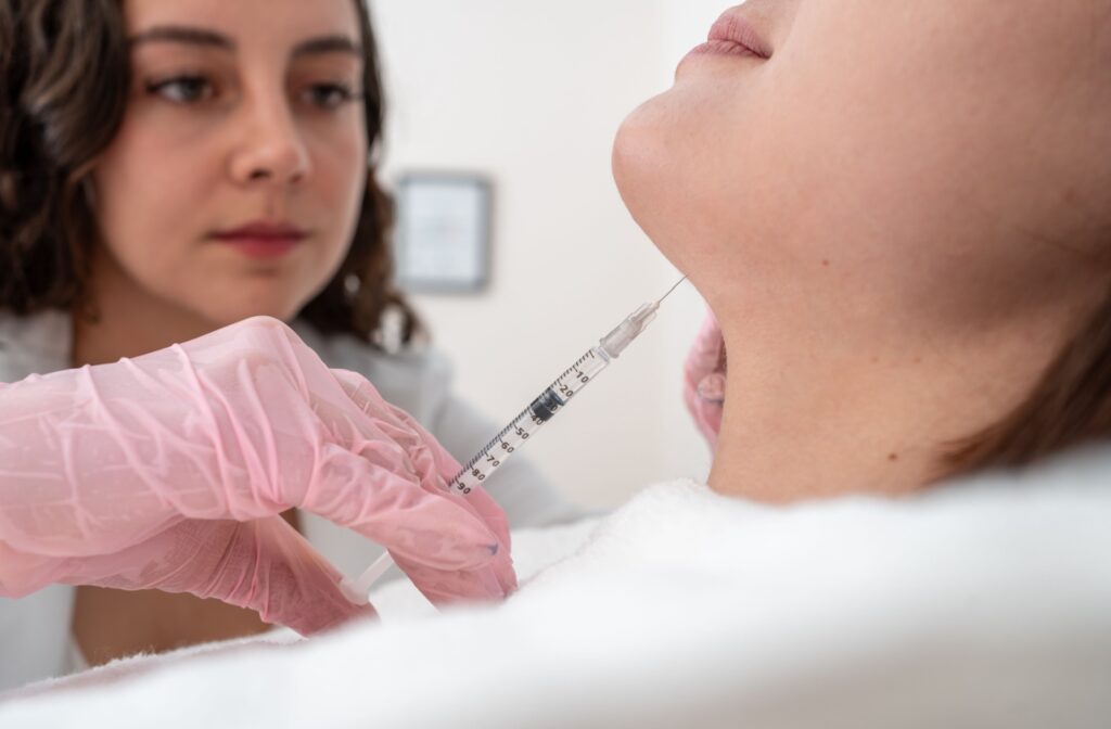 A close-up image of someone getting a Botox injection in their jaw to alleviate TMJ pain.