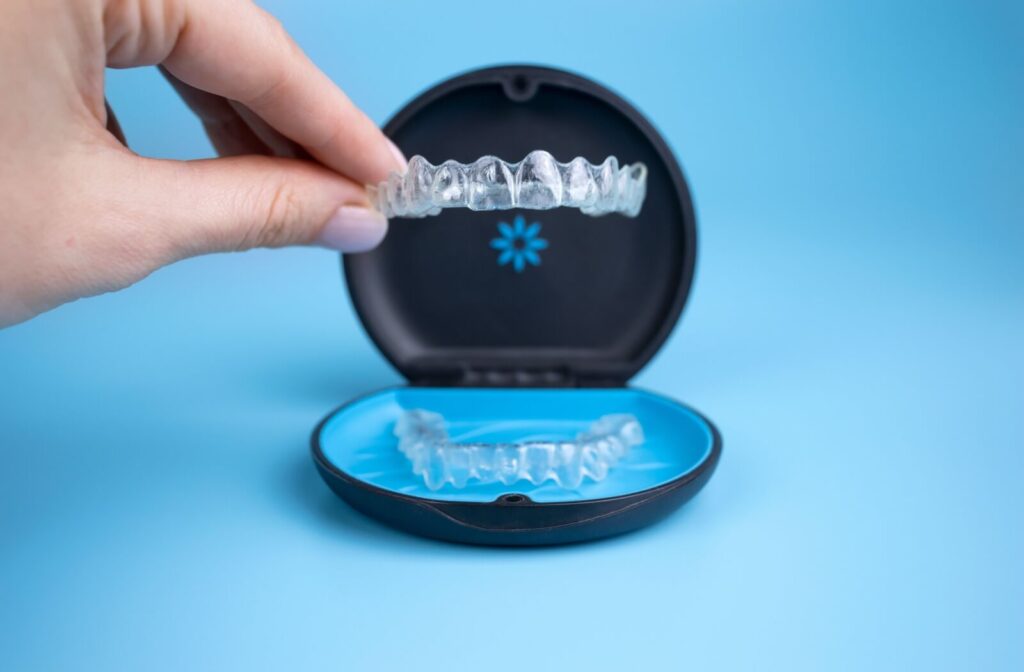 A person setting their Invisalign clear aligners into a protective carrying case.